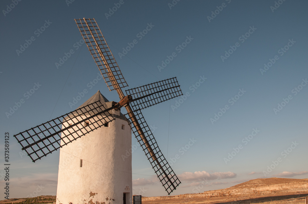 Vista cercana de un molino de viento español tradicional, como los que confundía Don Quijote de la Mancha en sus visiones por gigantes. Monumentos nacionales.