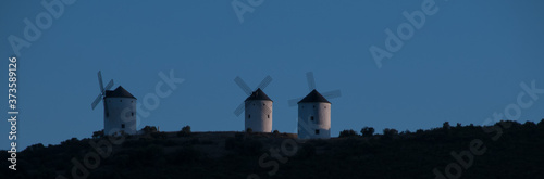 Horizonte copado por tres molinos de viento tradicionales fotografiados al atardecer en Campo de Criptana, España. Molinos con los que soñaba Don Quijote de La Mancha.