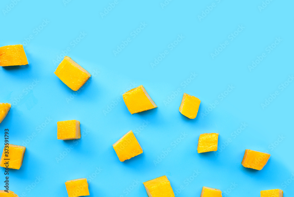 Sliced ripe mango cubes on blue background. Sliced ripe mango cubes on blue background.