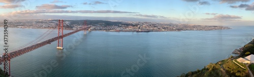 A statue of Cristo Rey and a view of the bridge named April 25 in Lisbon, Almada, Portugal.
