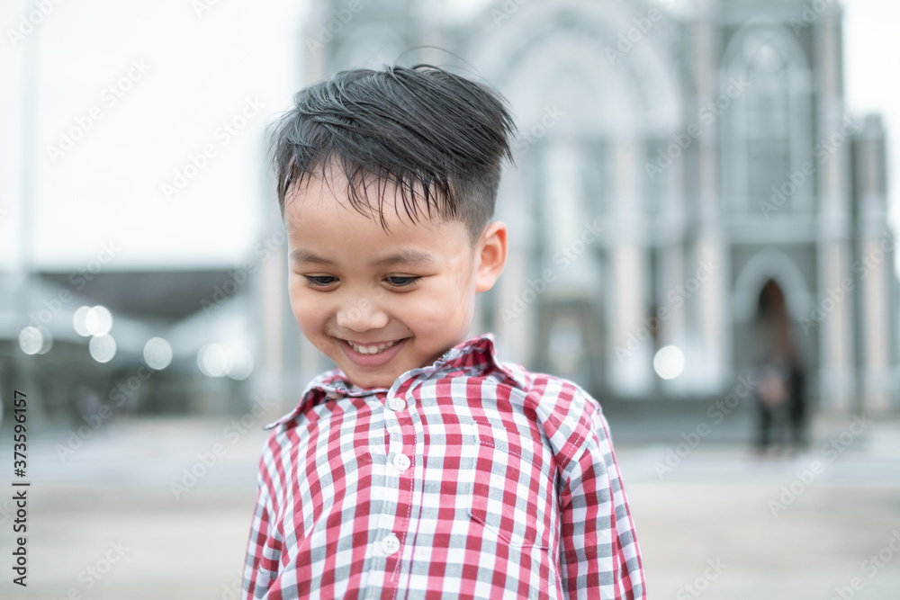 portrait of a handsome little Asian boy smiling alone in town square portrait of a handsome little Asian boy smiling alone in town square