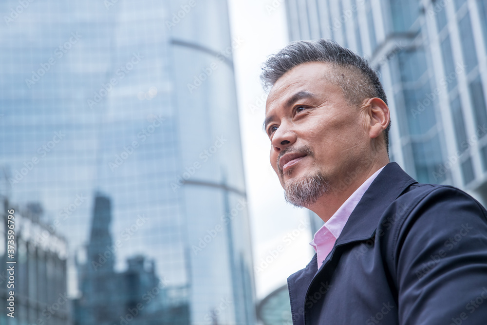 Middle-aged and old business man standing among buildings Middle-aged and old business man standing among buildings