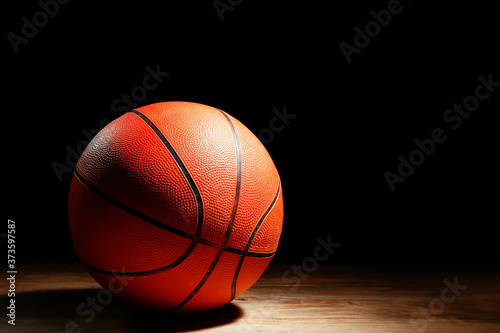 Ball for playing basketball on table against dark background © Pixel-Shot