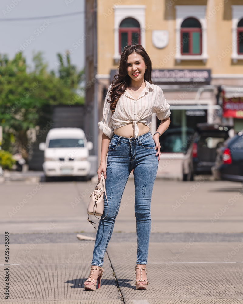 Happy Asia woman in bright blue skinny  jeans, sky blue jeans