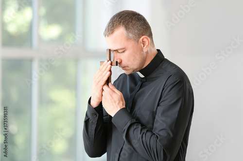 Portrait of praying male priest at home