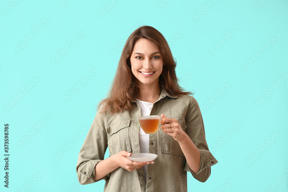 Beautiful young woman with cup of tea on color background Beautiful young woman with cup of tea on color background