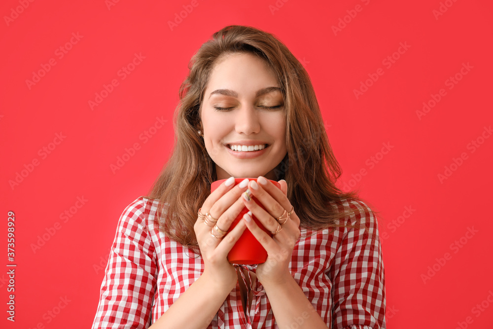 Beautiful young woman with cup of tea on color background Beautiful young woman with cup of tea on color background