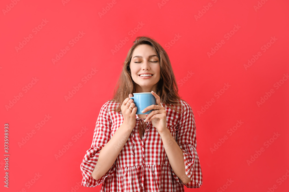 Beautiful young woman with cup of tea on color background Beautiful young woman with cup of tea on color background