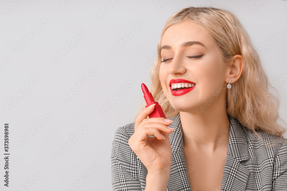 Beautiful young woman with bright lipstick on grey background Beautiful young woman with bright lipstick on grey background