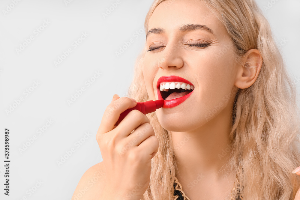 Beautiful young woman with bright lipstick on grey background Beautiful young woman with bright lipstick on grey background