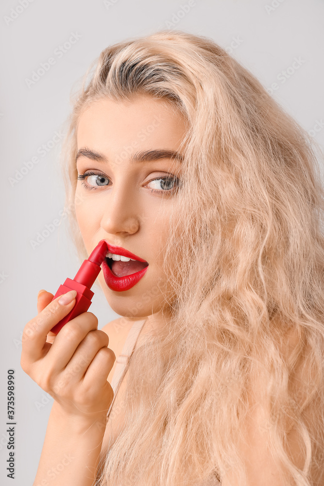 Beautiful young woman with bright lipstick on grey background Beautiful young woman with bright lipstick on grey background