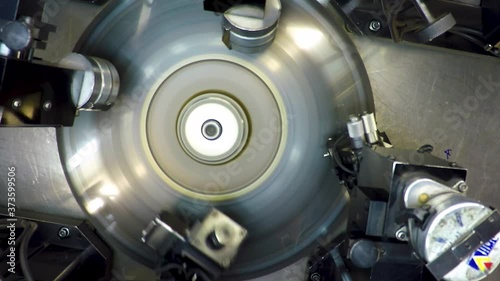 Top view of an automatic  bruting machine used in diamond industry, operated by an African woman with a loupe photo