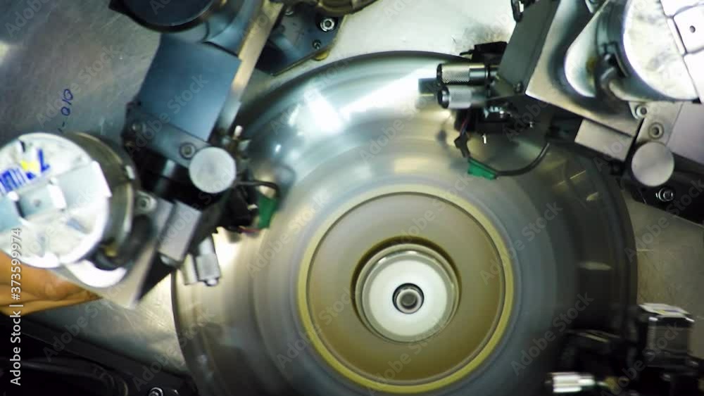 Top view of an automatic bruting machine used in diamond industry, operated by an African woman with a loupe Top view of an automatic bruting machine used in diamond industry, operated by an African woman with a loupe