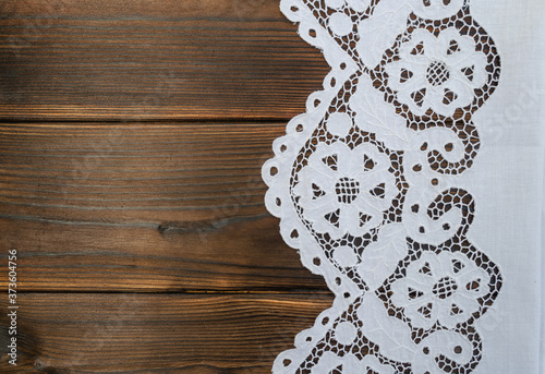 White lace handmade tablecloth on a wooden table on the right