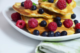 Homemade Belgium Waffles with fresh blueberries for breakfast. White plate, Viennese waffles with raspberries and mint. quick delicious breakfast on white background