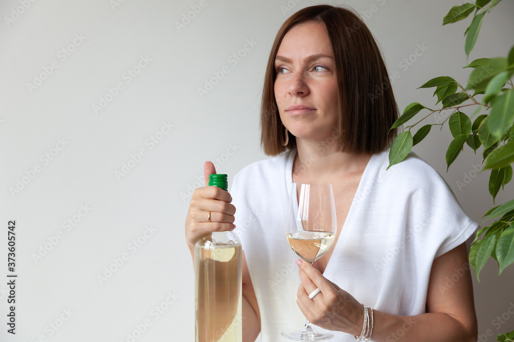 Caucasian brunette girl sommelier holding glass of white wine Caucasian brunette girl sommelier holding glass of white wine