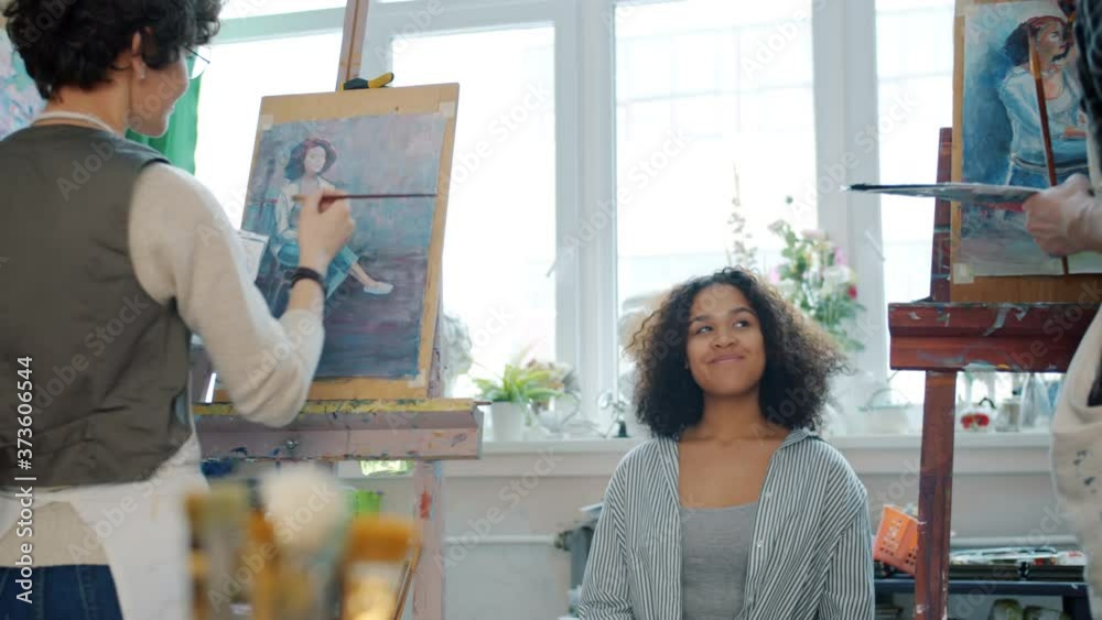 afro-american-woman-model-is-posing-for-young-artists-man-and-woman-in