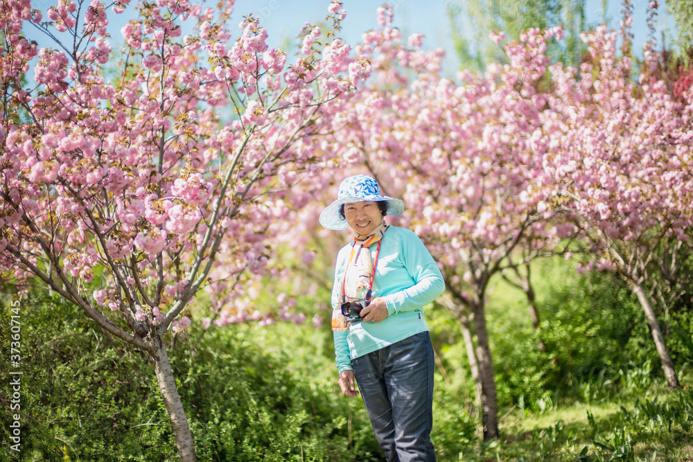 Portrait of happy senior beautiful woman in spring park 