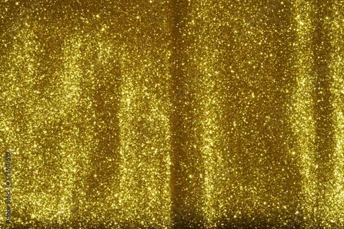 gold Sparkling Lights Festive background with texture. Abstract Christmas twinkled bright bokeh defocused and Falling stars. Winter Card or invitation	