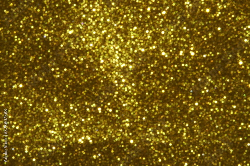 gold Sparkling Lights Festive background with texture. Abstract Christmas twinkled bright bokeh defocused and Falling stars. Winter Card or invitation 