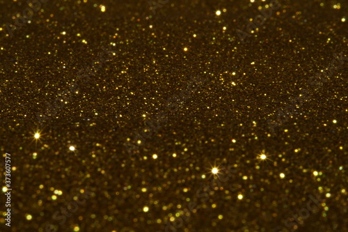 gold Sparkling Lights Festive background with texture. Abstract Christmas twinkled bright bokeh defocused and Falling stars. Winter Card or invitation	