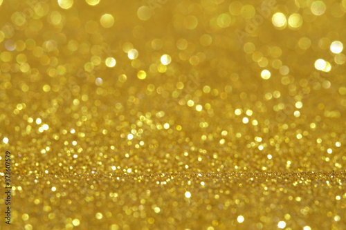 gold Sparkling Lights Festive background with texture. Abstract Christmas twinkled bright bokeh defocused and Falling stars. Winter Card or invitation	