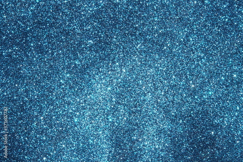 blue Sparkling Lights Festive background with texture. Abstract Christmas twinkled bright bokeh defocused and Falling stars. Winter Card or invitation	