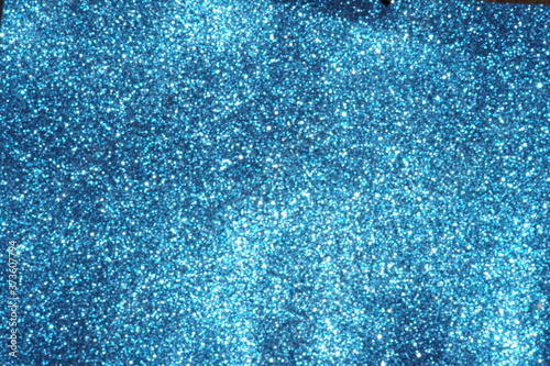 blue Sparkling Lights Festive background with texture. Abstract Christmas twinkled bright bokeh defocused and Falling stars. Winter Card or invitation	