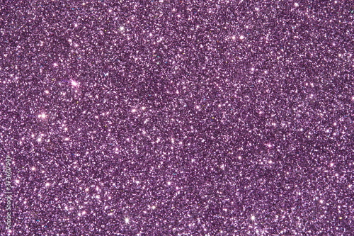 purple Sparkling Lights Festive background with texture. Abstract Christmas twinkled bright bokeh defocused and Falling stars. Winter Card or invitation	