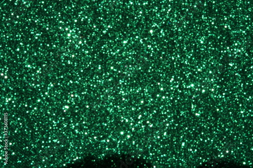 Green Sparkling Lights Festive background with texture. Abstract Christmas twinkled bright bokeh defocused and Falling stars. Winter Card or invitation	