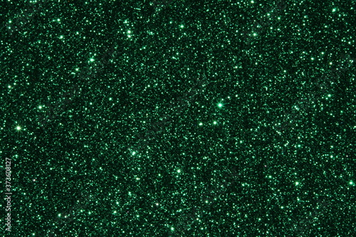Green Sparkling Lights Festive background with texture. Abstract Christmas twinkled bright bokeh defocused and Falling stars. Winter Card or invitation	
