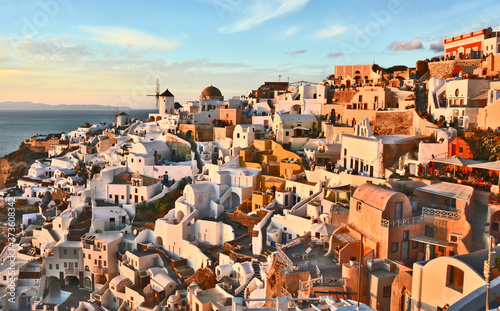 Oia village Thira Santorini Greece with sunset and blue sky.