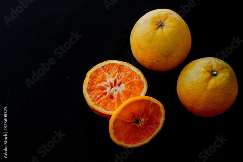 minimal fruit composition for breakfast with orange with a black background
