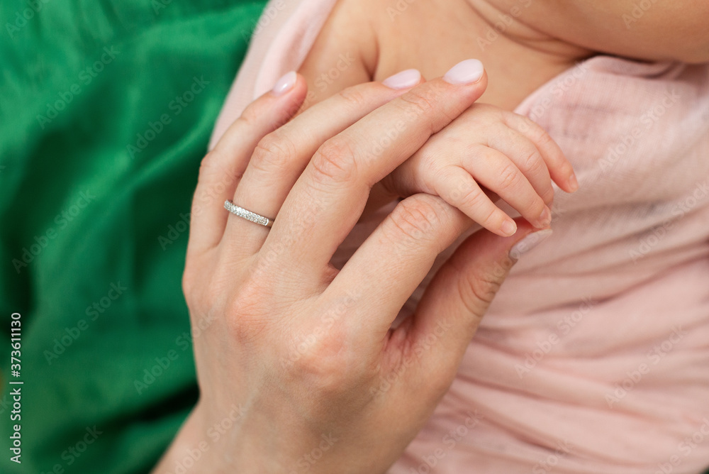 Fototapeta premium mom holds the hand of a newborn baby. Love and tenderness. Mothers Day.