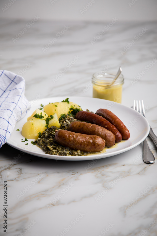 Oldenburger Grünkohl mit Pinkel, Kohlwurst, Senf und Kartoffeln auf Marmor Tisch