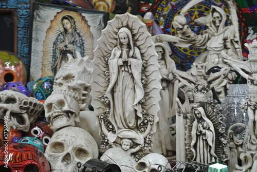 Statue of the Virgin Mary along with skull and other carvings in a souvenir shop in mexico