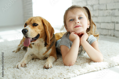 Little girl with a dog at home. High quality photo.