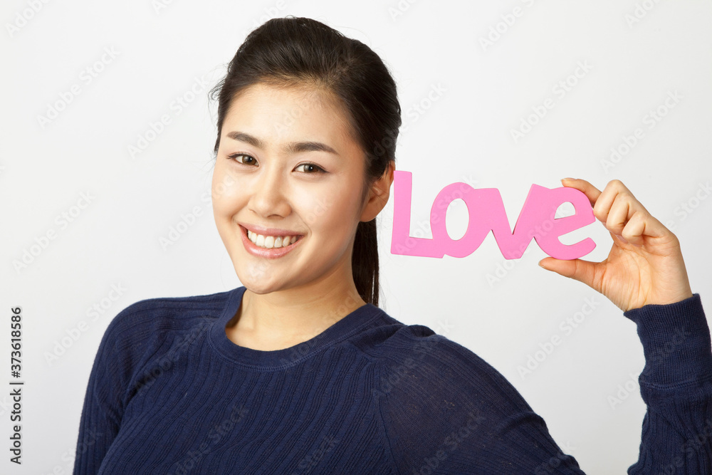 young woman holding a love sign young woman holding a love sign