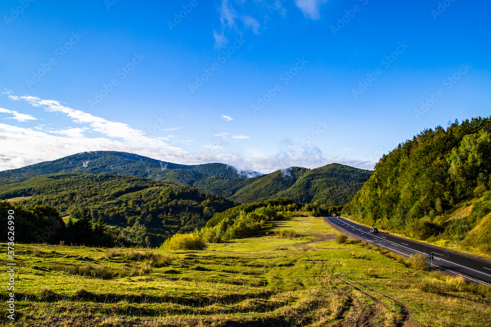 Asphalt road near mountains and forests. beautiful panorama.