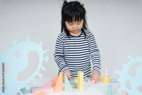 Pretty thai kid woman playing with toy block.