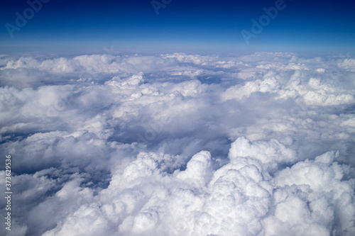 Floating clouds in the blue sky, view from airplane