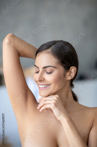 Smiling woman showing her shaved underarm photo