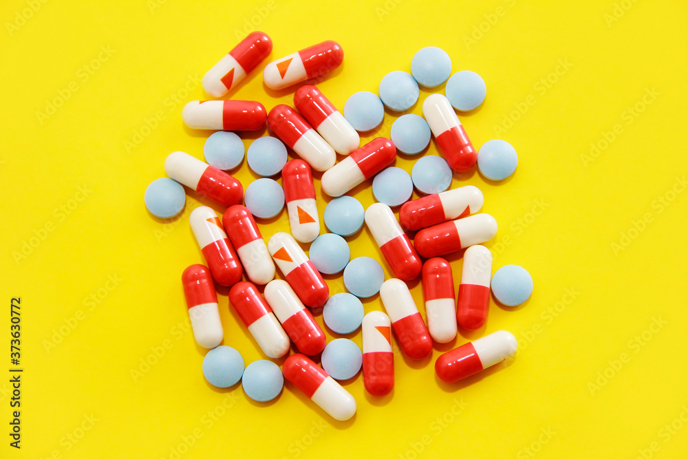 red and white medical capsules and tablets blue