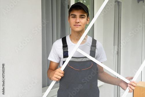 Man installs a mosquito net in the apartment. Protection from flying insects