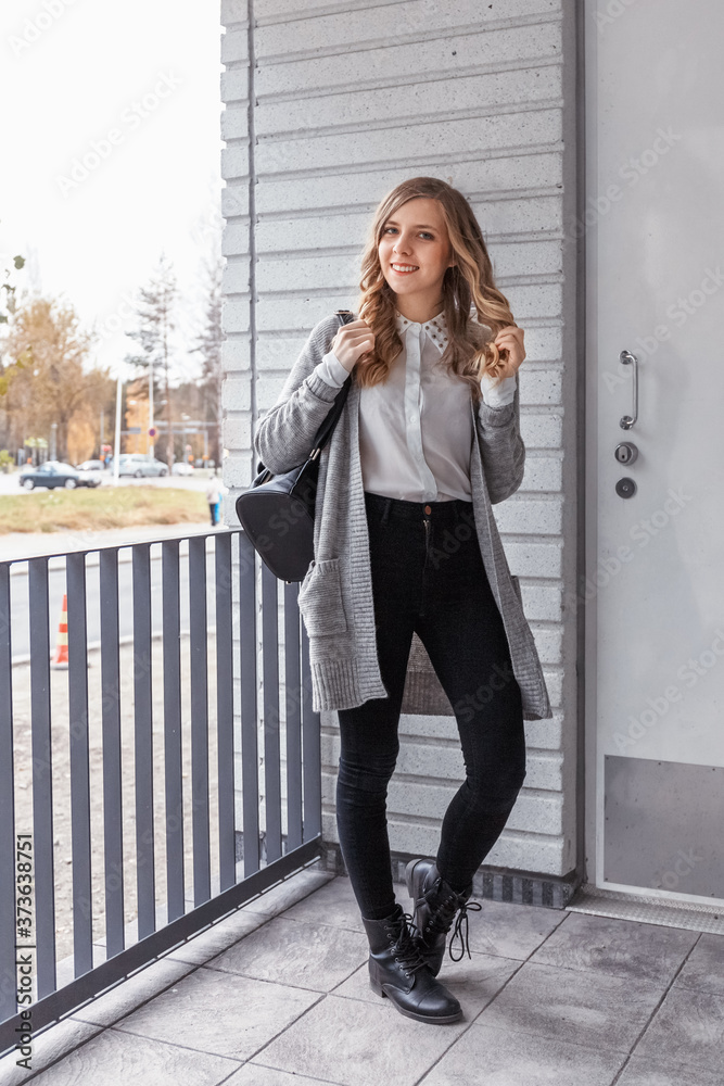 Fototapeta premium Portrait of stylish pretty young woman in autumn fashion walking in the city