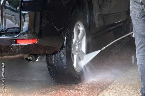 Car washing. Cleaning car with high pressure water and foam