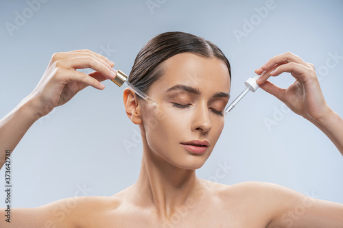 Female with closed eyes performing a beauty procedure