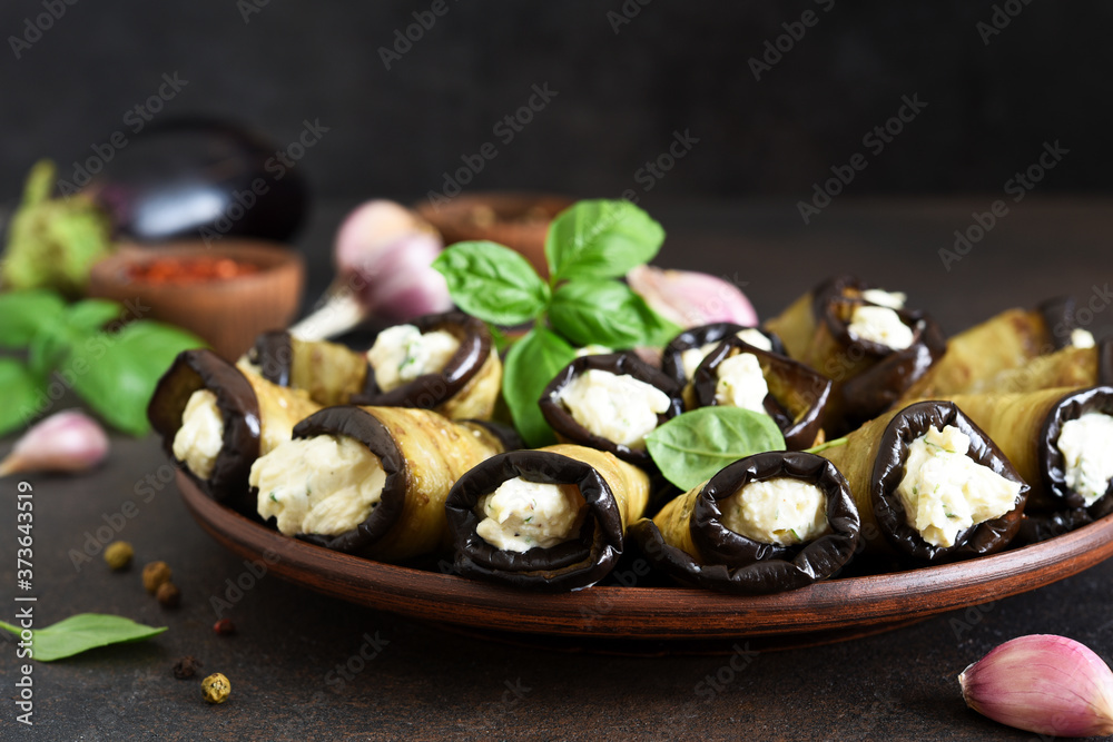 Grilled eggplants with cheese, nuts and garlic on a concrete background. Grilled eggplants with cheese, nuts and garlic on a concrete background.
