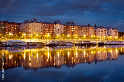 Block of of old bourgeois houses reflecting in a river by night