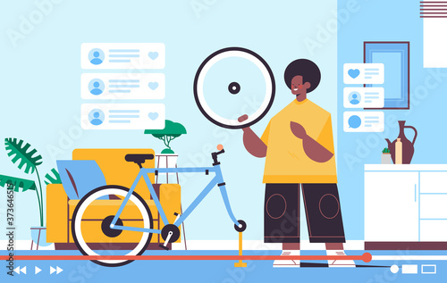 male blogger repairing bicycle recording online video blog live streaming blogging concept man checking tire defects workshop interior horizontal full length vector illustration